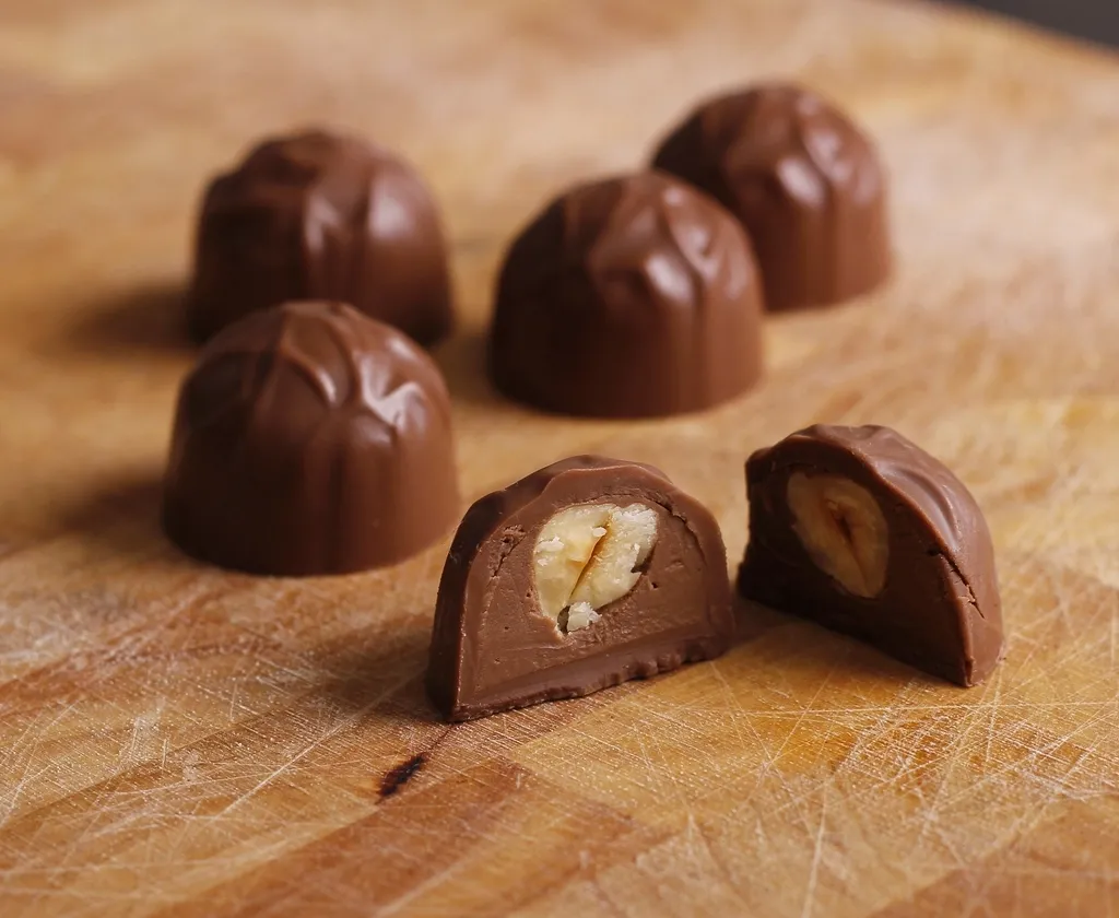 Bombons de chocolate sobre uma tábua de madeira.