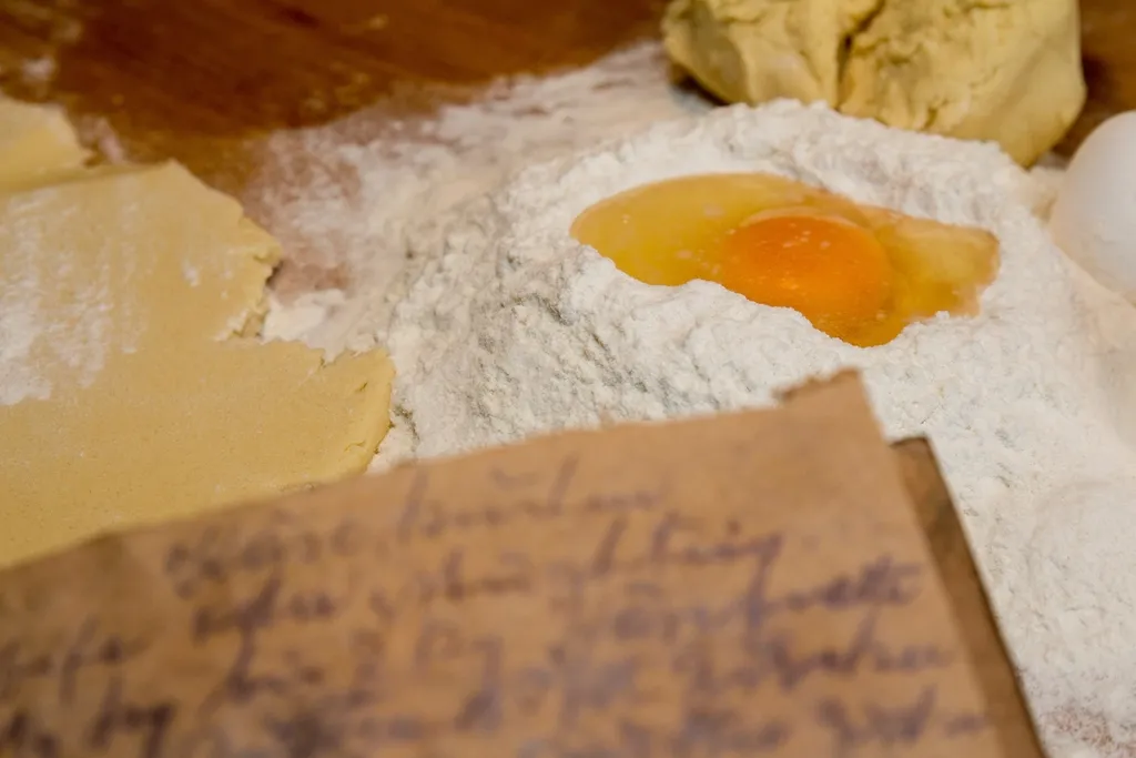 Farinha, um ovo e um caderno de receitas escrito à mão.